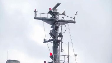 Bir gemi direği bulutlu bir gökyüzüne doğru yükseliyor. İçinde bir dizi seyrüsefer ekipmanı antenleri ve kırmızı ışık gözcüleri var. İtalya 'daki deniz tasarımının karmaşıklığını anlayabilirler.
