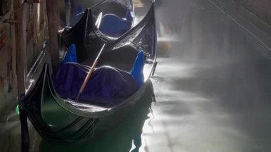 Gondollar, Venedik 'te sakin bir kanalda sabahın erken saatlerinde suyun yüzeyindeki yumuşak ışığı yansıtarak İtalya' da Venedik 'te barışçıl bir atmosfer yaratırlar.