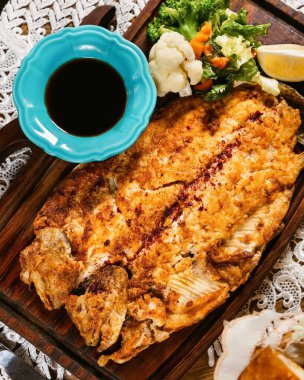 Tahta tahtada, soya sosu ve sebzelerle servis edilen damızlık fileto. Lezzetli ve sağlıklı bir yemek için mükemmel.