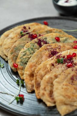 Tabakta servis edilen otlarla geleneksel dörtlüsü mikro yeşillik ve nar tohumlarıyla süsleniyor.