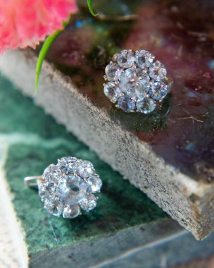 Aquamarine ve elmas küpe yeşil ve mor taş fayanslarda parlıyor.
