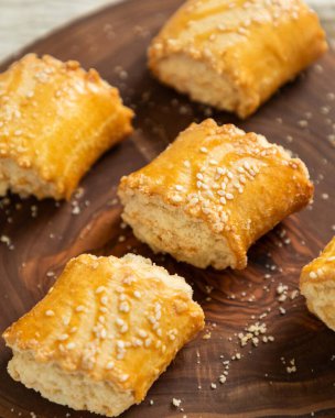 Susam tohumları serpiştirilmiş lezzetli gata hamur tatlısı, kırsal bir tahtanın üzerinde duruyor.