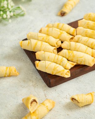 # Tatlı dolgulu lezzetli rugelach hamur işleri # # Şeker jölesiyle serpiştirilmiş # # Tahtanın üzerinde yatıyor #