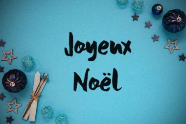 Joyeux Noel 'in Fransızca mesajlı Noel Kartı Mutlu Noeller demek. Turkuaz Noel Arkaplanı Balo, Yıldız ve Kayak gibi dekorasyonlarla.