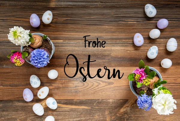 Easter Flat Lay With German Text Frohe Ostern Means Happy Easter. Flowers With Easter Egg Decoration And Ornament. Hyacinth Flower Arrangement With Wooden, Vintage Background.