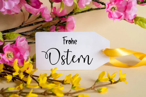 Spring Flower Arrangement With White Label With German Text Frohe Ostern Means Happy Easter. Colorful Flower Branch Decoration With Yellow And Purple Blossoms.