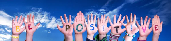 孩子们手握多彩的英语单词要积极 蓝天为背景 — 图库照片