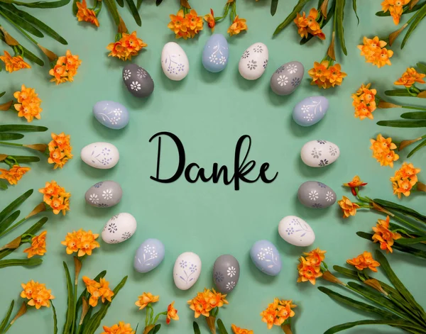 德国文平铺丹麦文表示 复活节彩蛋装饰与橙色春花 浅绿色纸背景 — 图库照片