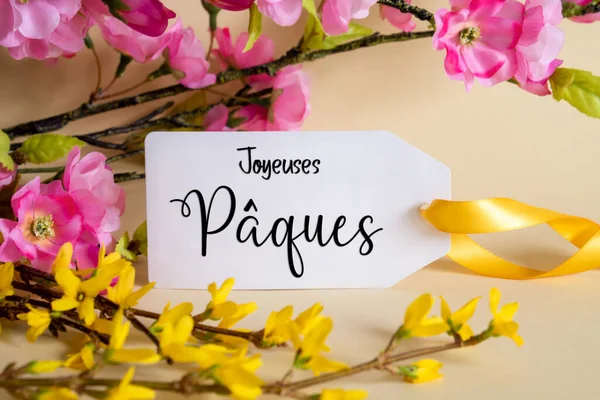 Spring Flower Arrangement With White Label With French Text Joyeuses Paques Means Happy Easter. Colorful Flower Branch Decoration With Yellow And Purple Blossoms.