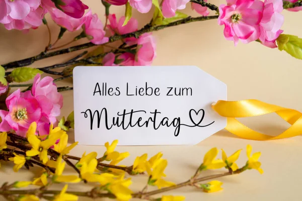 春の花のアレンジメントドイツ語のテキストが付いている白いラベルAlles Liebe Zum Muttertagは幸せな母の日を意味します 黄色と紫の花とカラフルな花の枝の装飾 — ストック写真