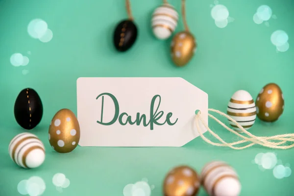 带有德语文本的标签Danke意为 明亮的金色 黑色复活节彩蛋装饰 旺季贺卡 浅绿色或绿松石背景 — 图库照片