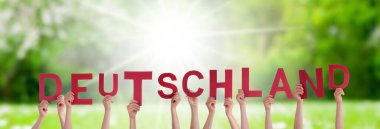 Alman Sözcükleri 'ni inşa eden İnsan veya İnsan Elleri Almanya demektir. Arkaplan Olarak Güneşli Yeşil Çimen Çayırı.