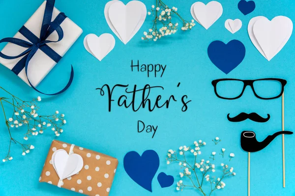 Flat Lay With English Text Happy Fathers Day. Blue Accessories Like Presents, Hearts, Flowers And Male Decoration Like Mustache. Flat Lay With Turquoise Paper Background.