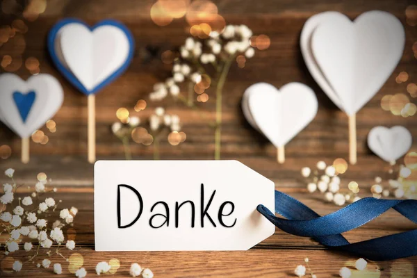 带有德语文本的标签Danke意为 白色的节日和大气的装饰像心 花和蓝色的弓 古色古香 木制背景 闪烁着光芒 — 图库照片