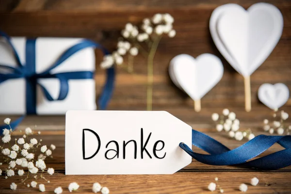 带有德语文本的标签Danke意为 白色的节日装饰像礼物 蓝弓形 心和花 古董木背景 — 图库照片