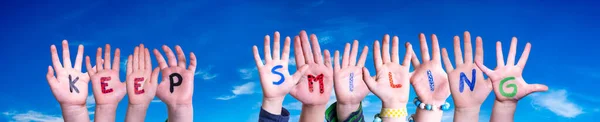 孩子们手握多彩的英语单词 保持微笑 蓝天为背景 — 图库照片