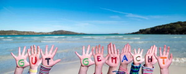 孩子们手握彩色德语单词Gut Gemacht意为 做得好 夏季海 滩背景 — 图库照片