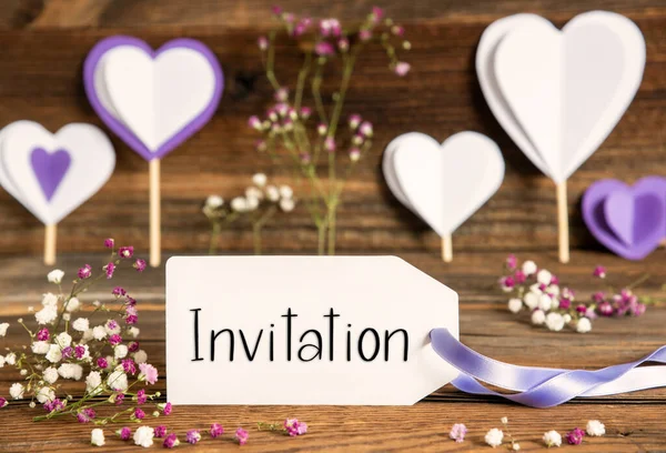 英語のテキスト招待状付きのラベル パープルとライラックの装飾と春の花のアレンジメント 木製の背景を持つハートシンボル — ストック写真
