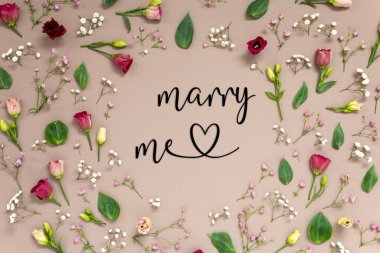 İngilizce Mesajlı Çiçek Düzenleme Benimle Evlen. Renkli Bahar Çiçekleri ve Güller Çerçeve Yapıyor gibi Çiçekler. Kahverengi kağıda sahip düz bir zemin