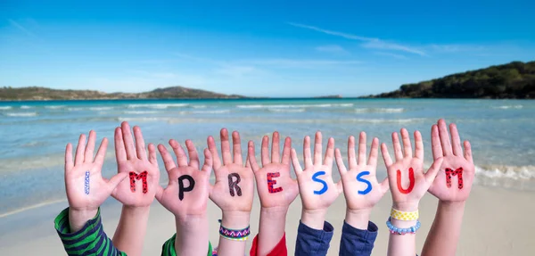 孩子们手拉着彩色德语单词Impressum的意思是印记 夏季海 滩背景 — 图库照片
