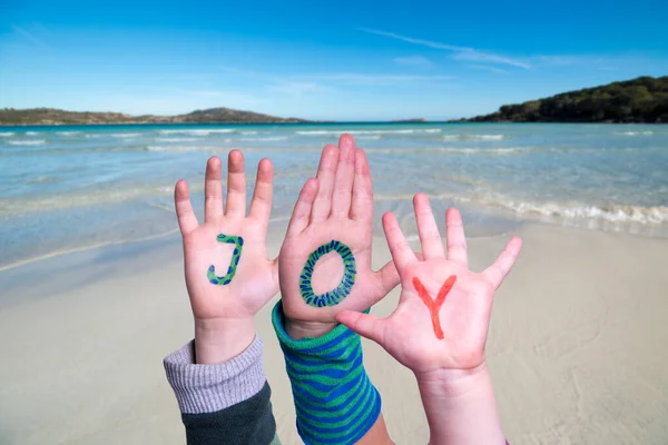 子供の手カラフルな英語の単語喜びを構築します 背景として夏の海 海とビーチ — ストック写真