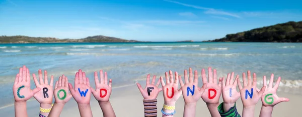 子供の手カラフルな英語の単語群集資金を構築する 背景として夏の海 海とビーチ — ストック写真