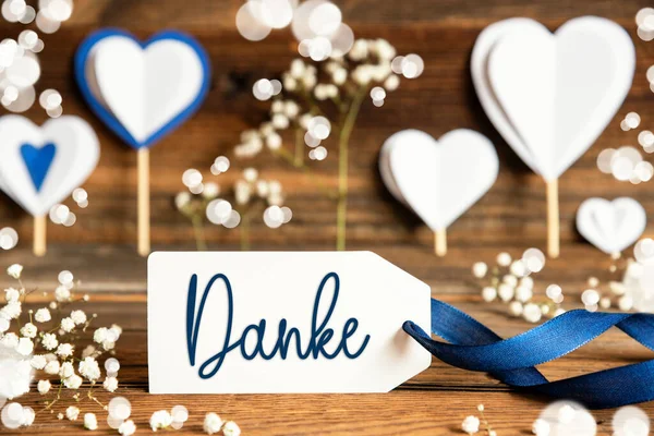 带有德语文本的标签Danke意为 白色的节日和大气的装饰像心 花和蓝色的弓 木制背景 — 图库照片