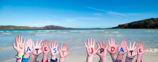 子供の手カラフルな英語の単語の最新アップデートを構築します 背景として夏の海 海とビーチ — ストック写真