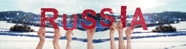 人々は英語の単語ロシアを構築する手をします 白い冬の背景と雪の風景 — ストック写真