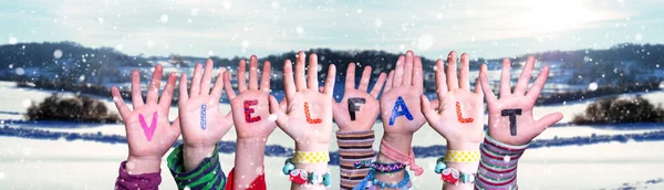 孩子们手握彩色德语单词Vielfalt意味着多样性 白雪覆盖的冬季背景与雪景 — 图库照片