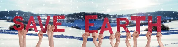 人々は 英語の単語を保存する地球を構築する手をします 白い冬の背景と雪の風景 — ストック写真