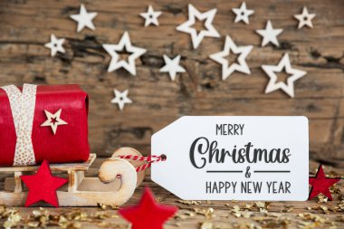 Kırmızı hediyeli ahşap kızak ve etiketli kırsal Noel geçmişi Mutlu Noeller ve mutlu yıllar
