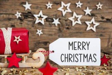 Kırmızı hediyeli ahşap kızak ve Mutlu Noeller yazılı etiketli köylü Noel geçmişi