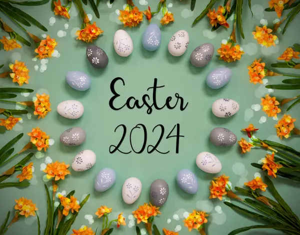 平躺在英文文本旁边的复活节2024年 复活节彩蛋装饰与橙色春花 浅绿色纸背景 光亮度大 效果好 图库图片