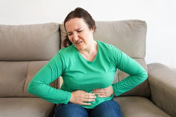 Frau Hat Bauchschmerzen Wenn Sie Hause Auf Dem Sofa Sitzt — Stockfoto