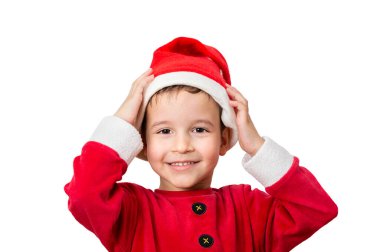Studio shot of a cheerful boy posing and putting on his Santa hat while standing on a white background.