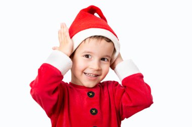 Studio shot of a cheerful child posing in a santa hat while standing against a white background