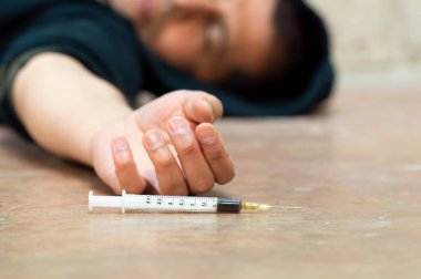 Guy crazy drug addict reaches for another dose of the drug in the syringe.The concept of anti drugs. male drug addict, drug syringe.