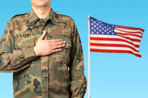 An American soldier swearing allegiance and the flag of his country in the background