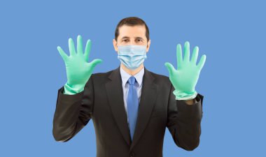 Happy businessman with face mask and gloves ready to do homework on blue background.
