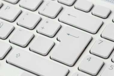 Close-up of a computer keyboard with focus on the enter key.