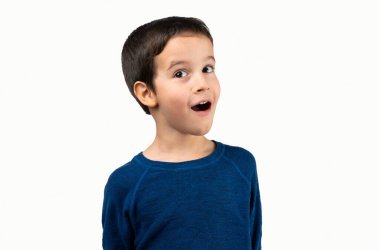 Dark haired little child making listen gesture with shocked face, looking skeptical and sarcastic, surprised with open mouth isolated on white