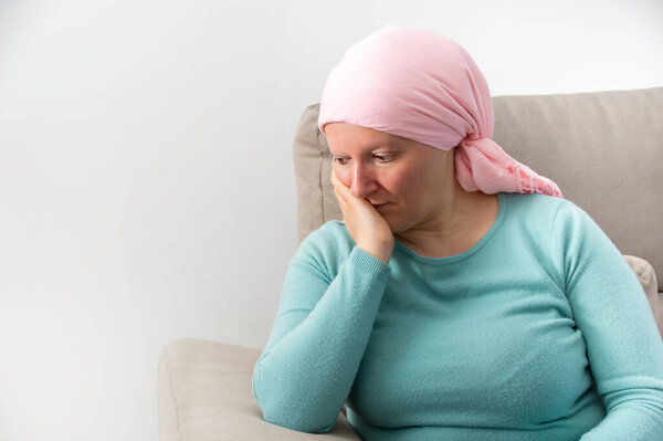 Mature woman suffering from cancer sitting after taking chemotherapy sessions and worried about her illness