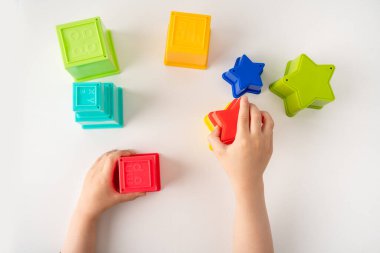 High angle shot of hands playing with toy cubes and stars,educational games
