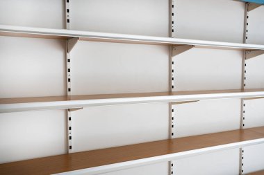 Side view empty supermarket shelves from the front on white