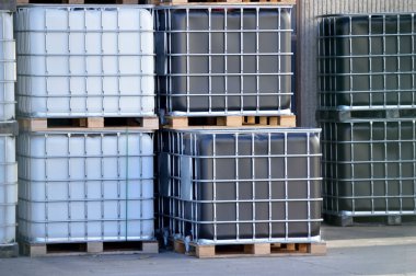 A stack of freight containers in rows at the factory with liquid inside