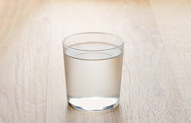 Water on glass on wooden table