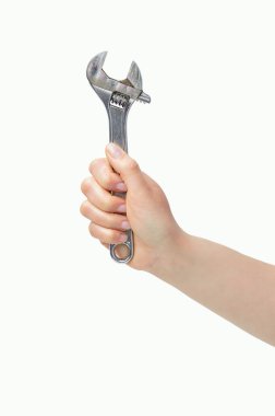 Beyaz bir arka plan üzerinde izole bir somun anahtarı tutan kadın eli