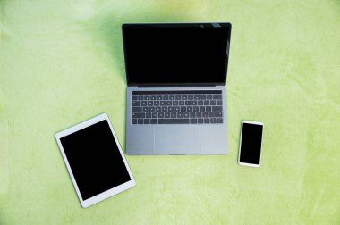 Shot of various digital devices on a green carpet at home