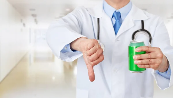 Front view close up of a doctor hands holding a soda drink can with thumb down at hospital